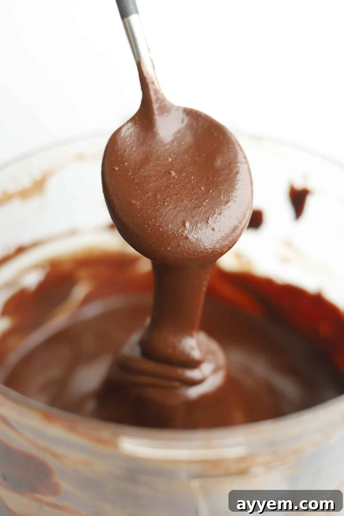 A spoon full of rich, homemade espresso Nutella, showcasing its smooth, creamy texture.