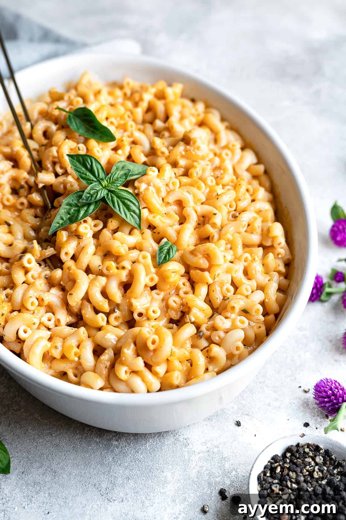 Close-up side view of gooey baked mac and cheese with a golden crust in a baking dish.