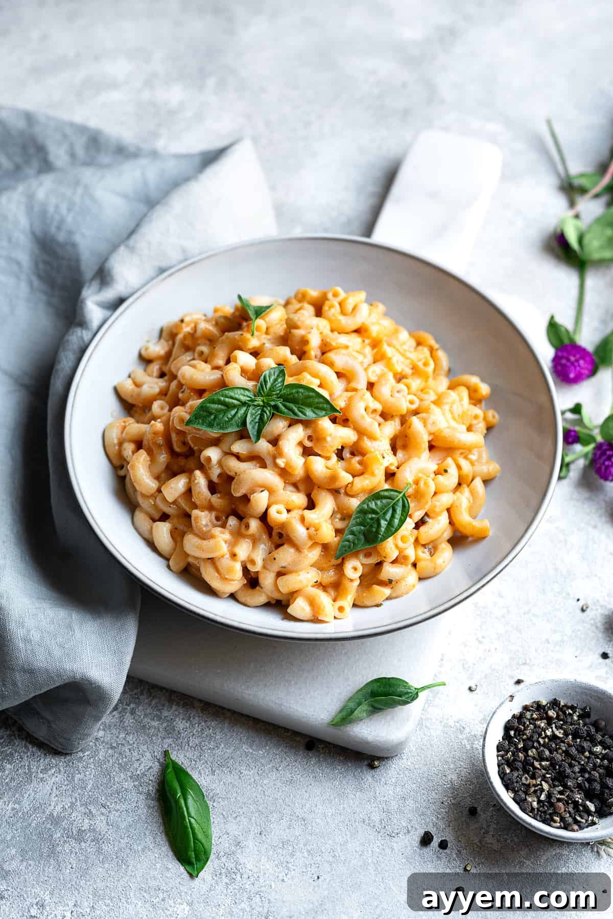 A bowl of easy baked mac and cheese, topped with fresh chopped parsley, ready to be served.