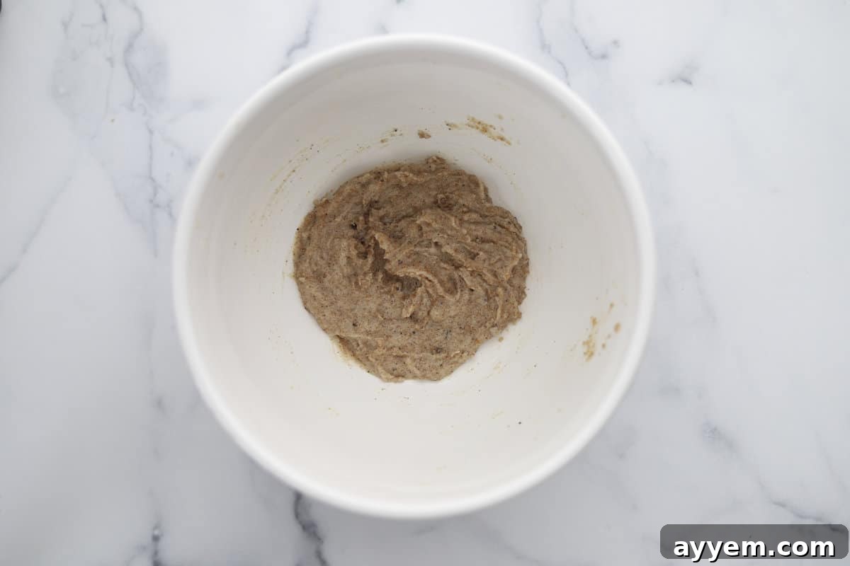 Wet ingredients for Mom's Recipe Crumbl Cookies, including eggs and vanilla, perfectly combined in a mixing bowl.