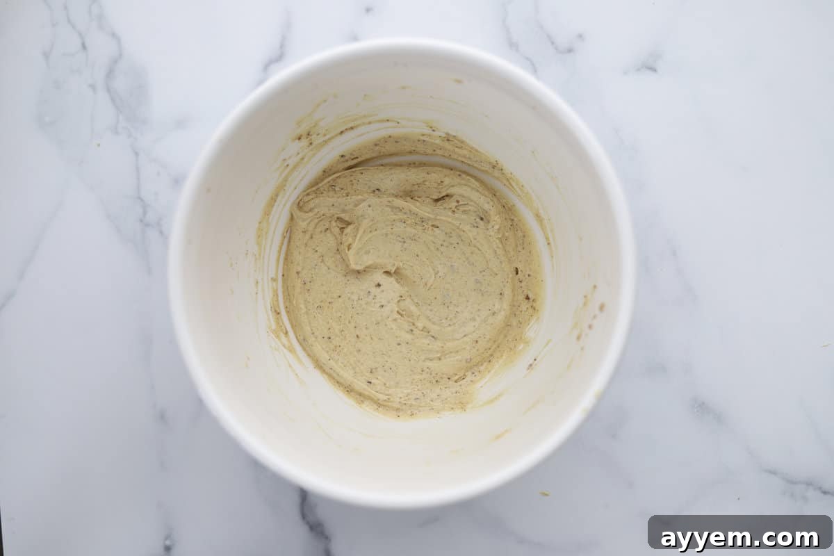 Dry ingredients being gently folded into the wet mixture to form the cookie dough for copycat Mom's Recipe cookies.