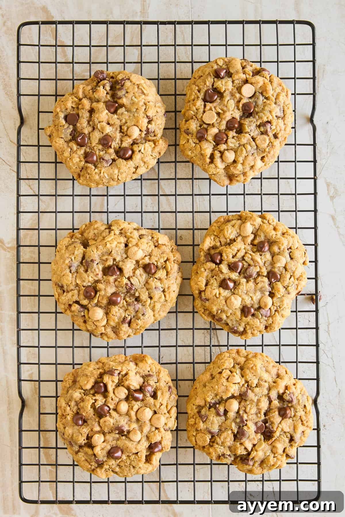 Six perfectly baked copycat Crumbl Mom's cookies cooling on a wire rack, ready to be enjoyed.