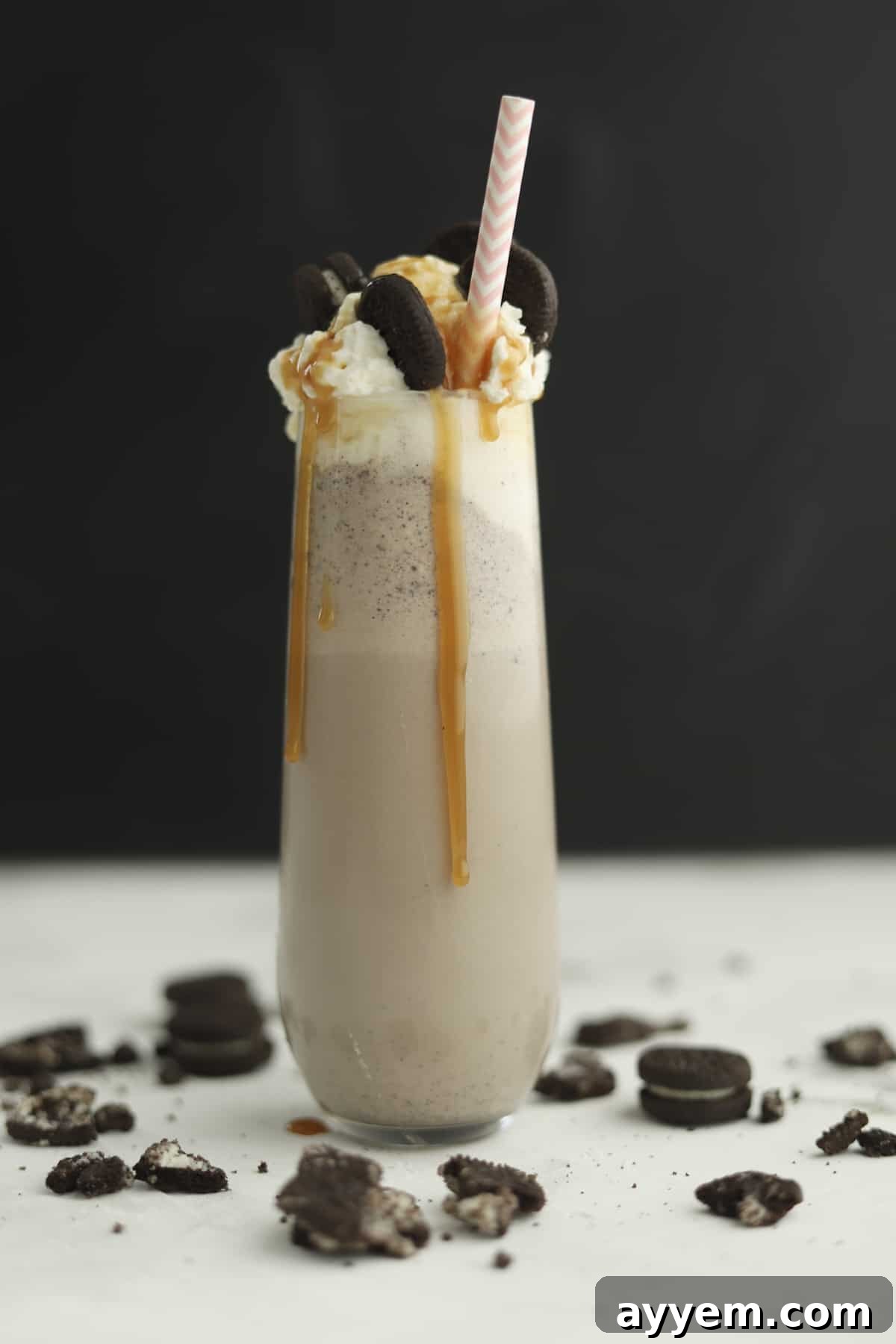 side view of oreo frappuccino with caramel dripping down the side and straw