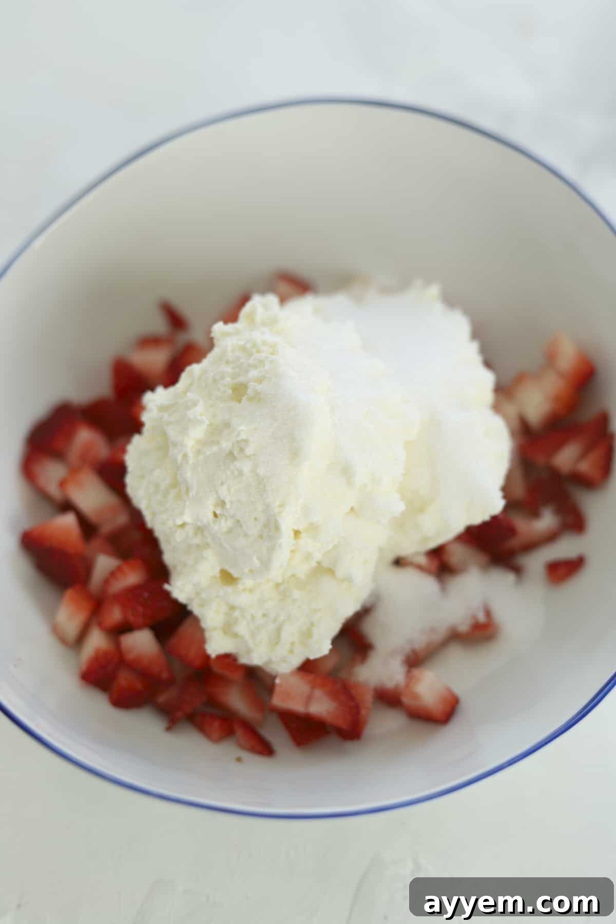strawberries in a bowl with cream cheese on top 