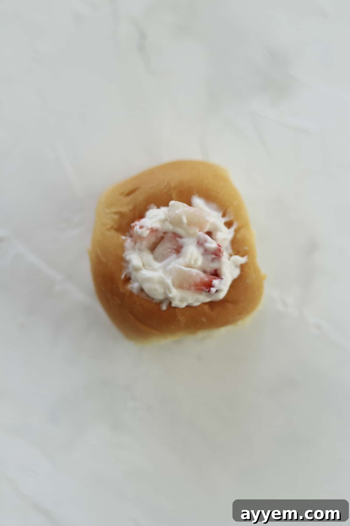 a Hawaiian roll with strawberry cream cheese in the center