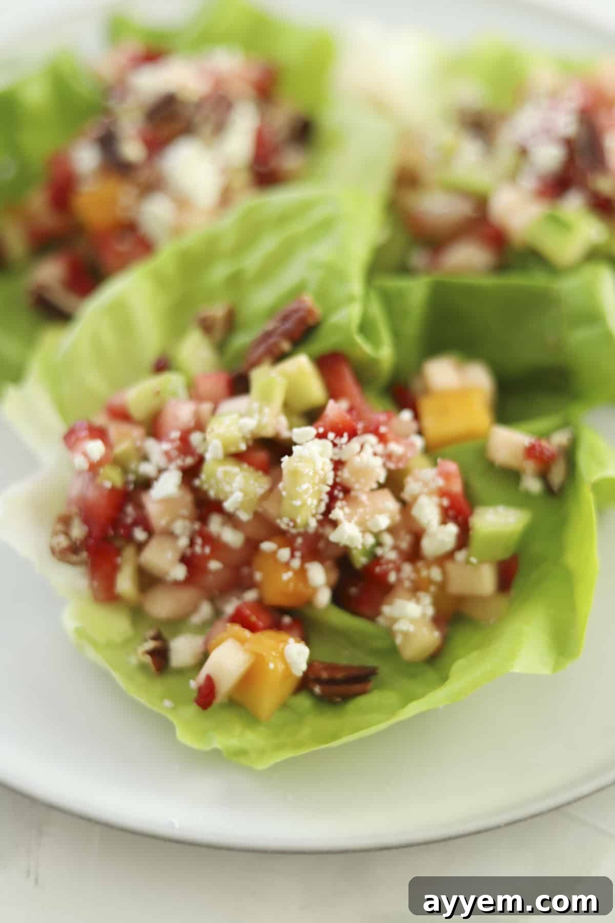 A platter of beautifully arranged fruit salad lettuce cups, ready to be served.