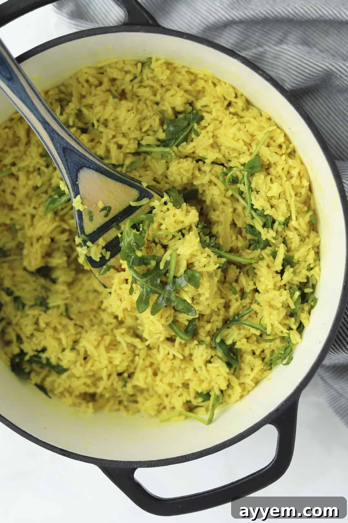 A close-up shot of Coconut Turmeric Rice in a pot, highlighting its texture and golden color