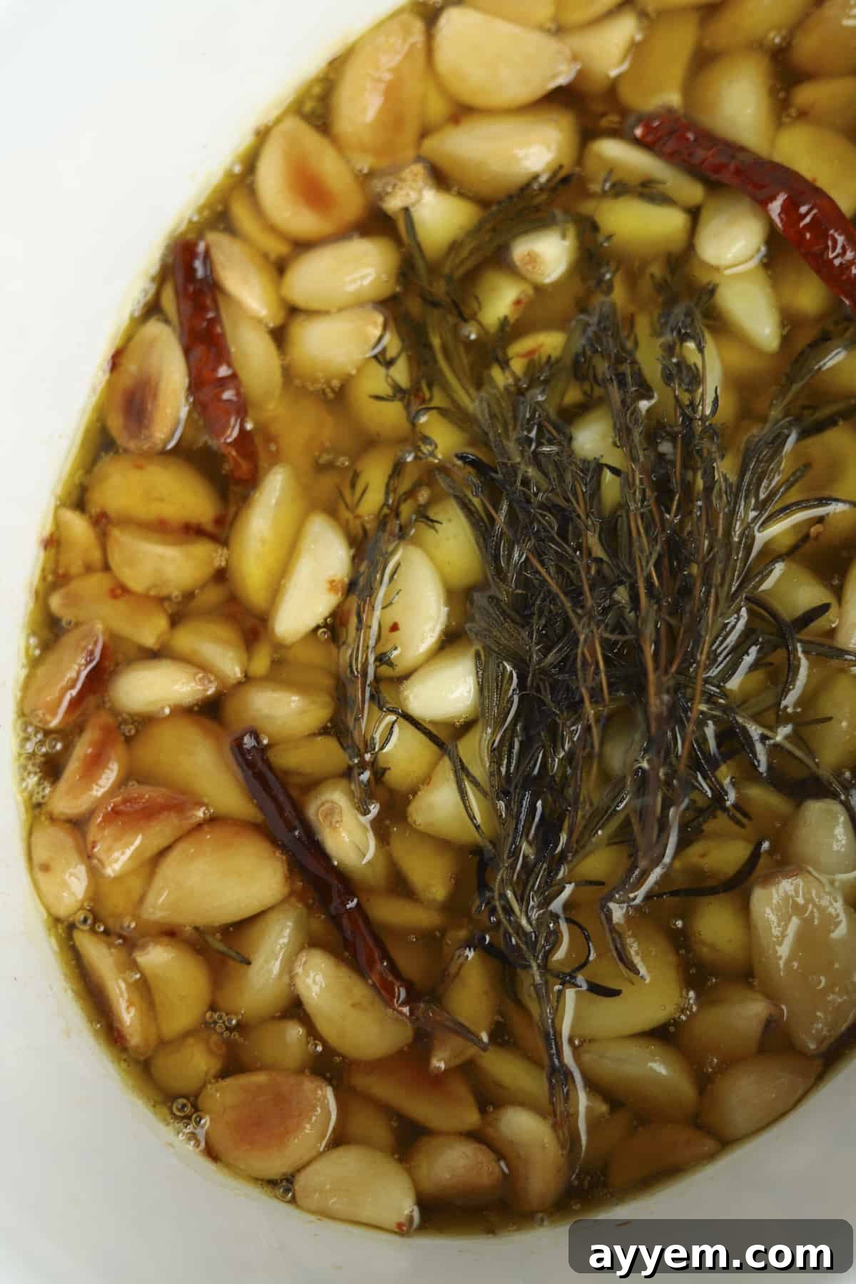 Slow cooker garlic confit after cooking, with golden, tender cloves visible.