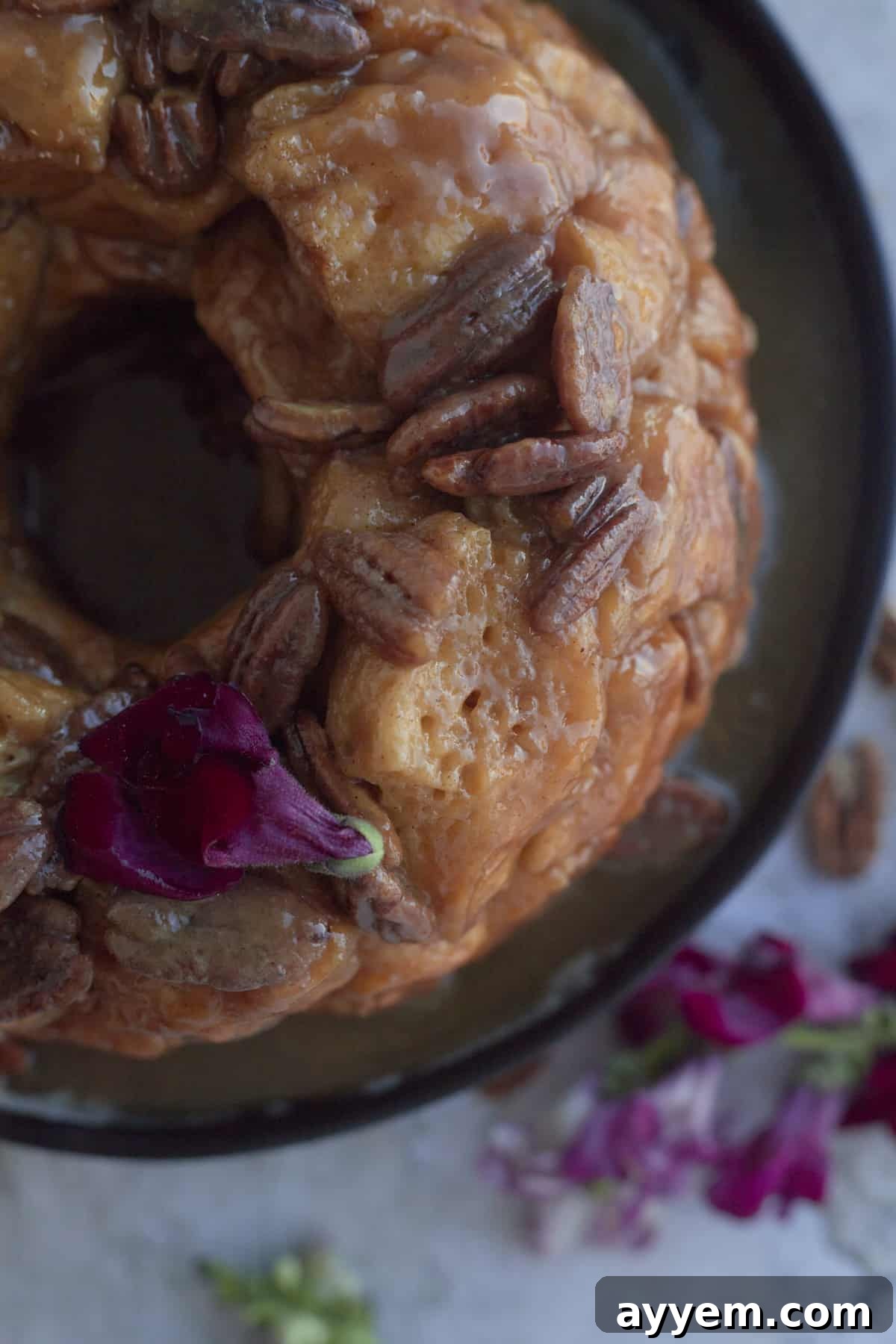 A close-up view of the golden-brown caramel pecan homemade monkey bread, with individual sticky pieces visible, ready to be pulled.