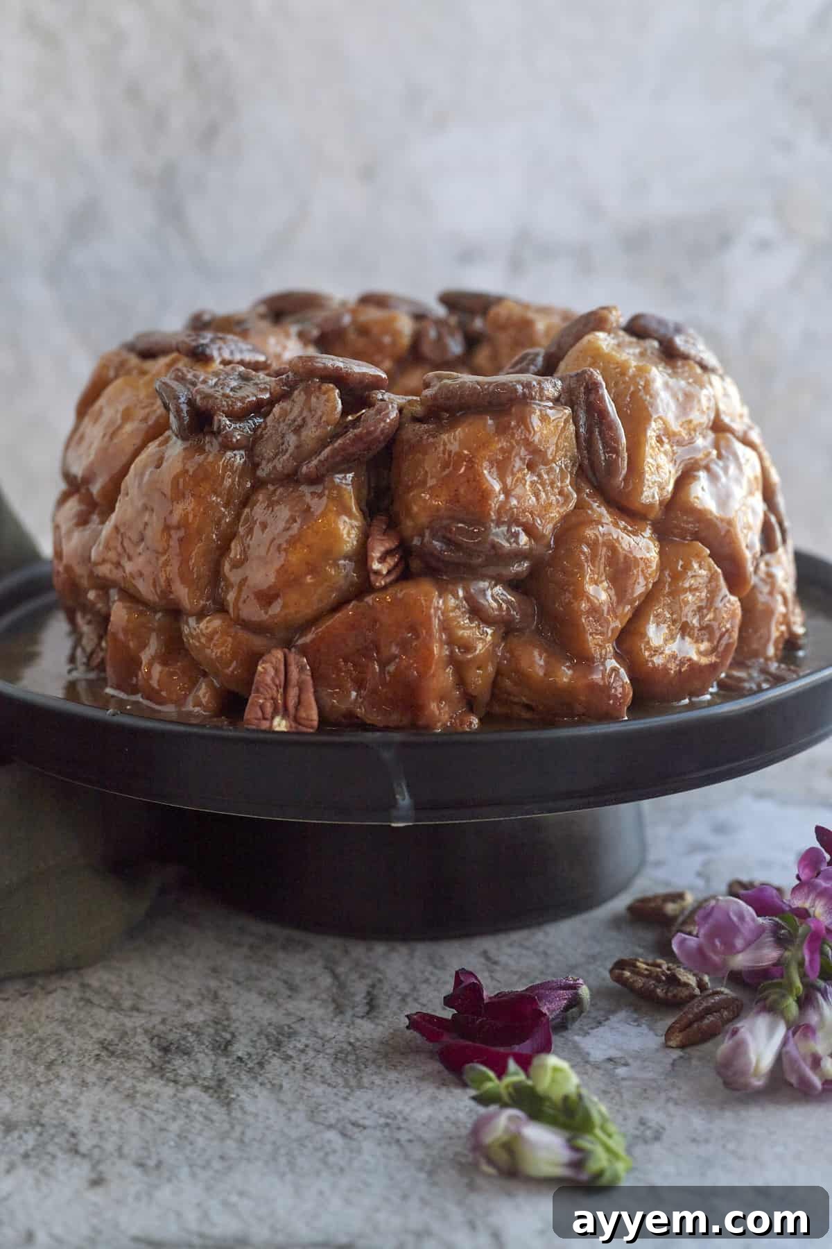 A side view of a sliced piece of pecan caramel homemade monkey bread, revealing its soft, fluffy interior and the gooey caramel and nuts.