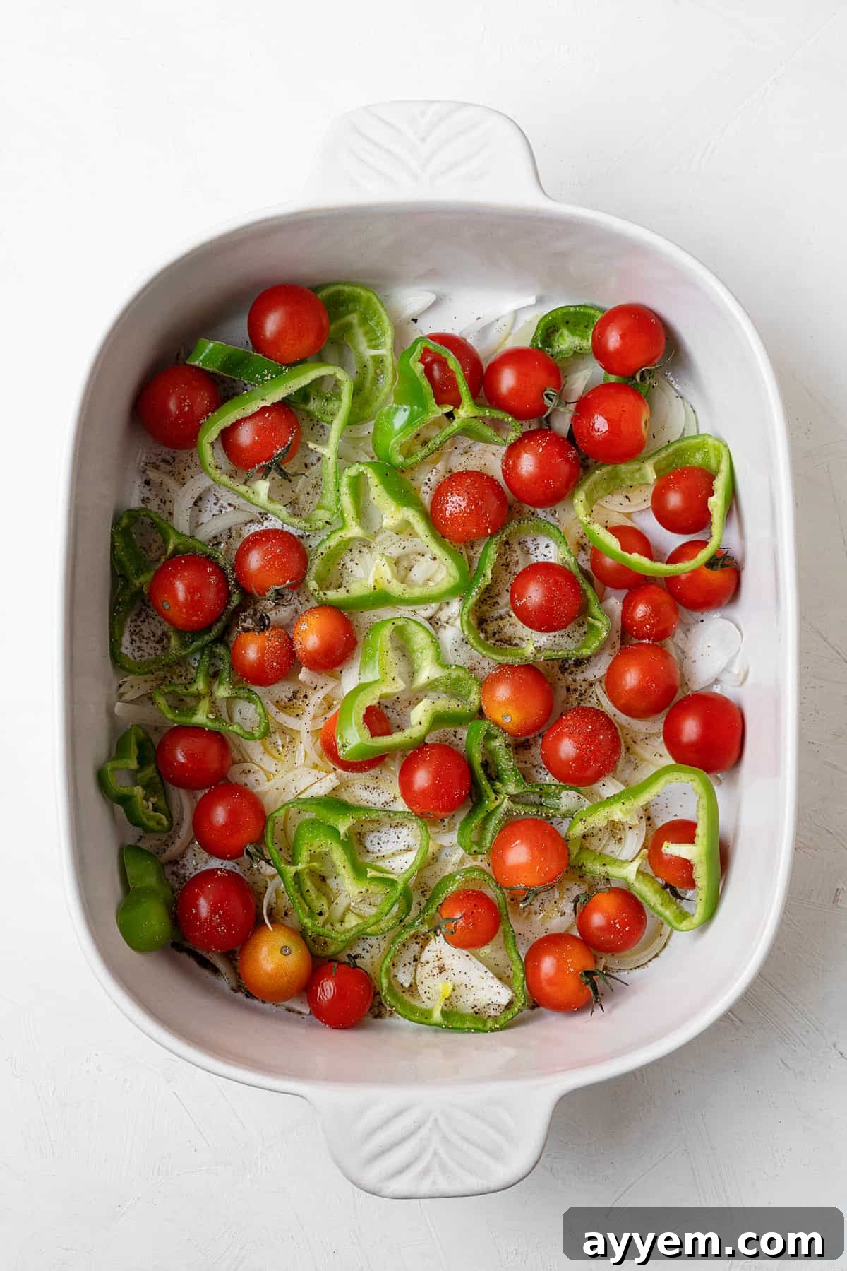 overhead baking dish with tomatoes peppers and seasoning