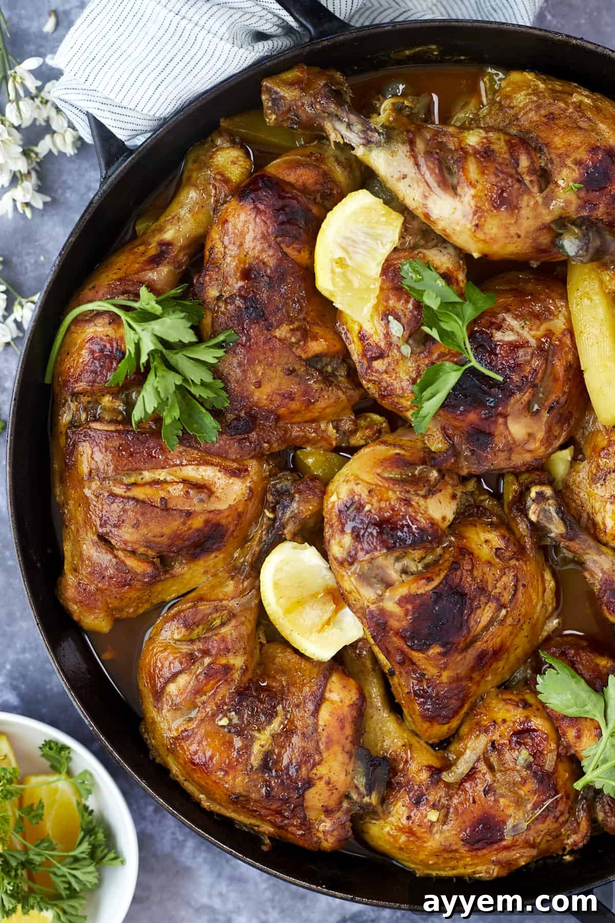 A spread of Middle Eastern chicken and potatoes with side dishes, presented on a rustic wooden board.