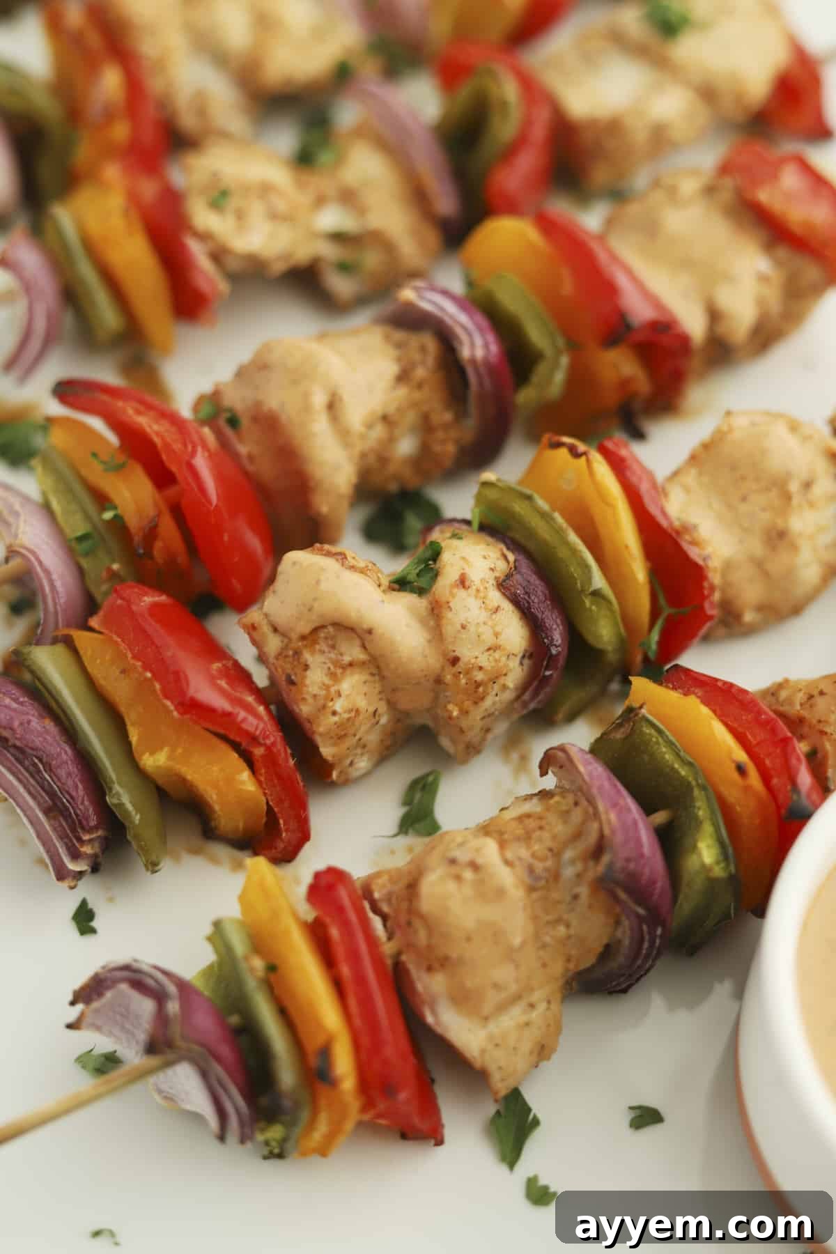 oven-baked chipotle chicken skewers with red, yellow, and green peppers and red onion