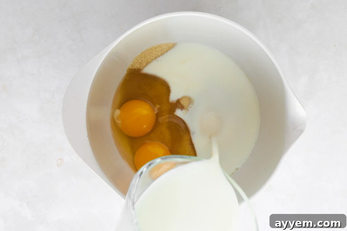 Eggs, milk, and sugar being combined in a bowl.