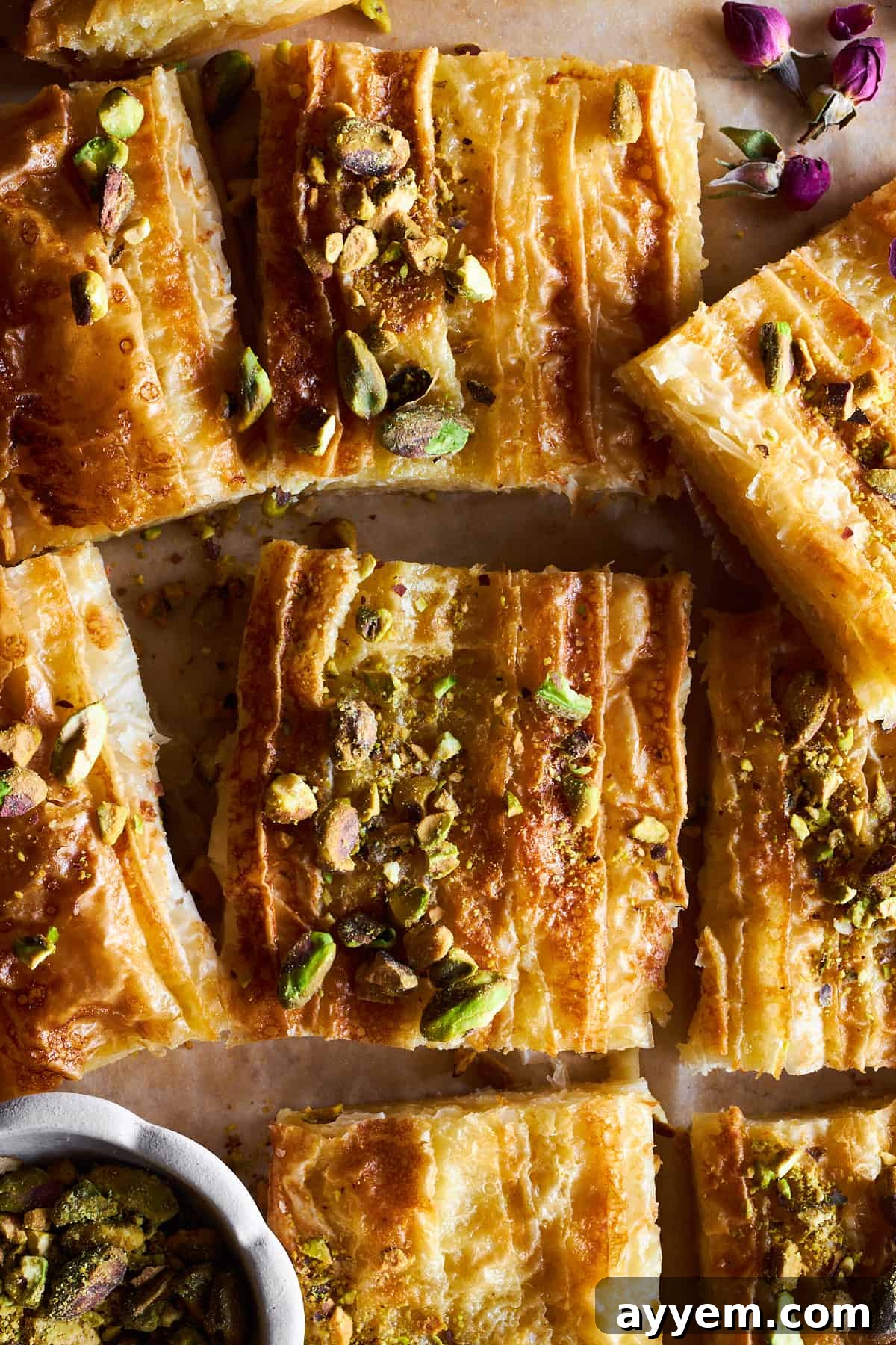 Squares of baked crinkle phyllo dough topped with pistachios.