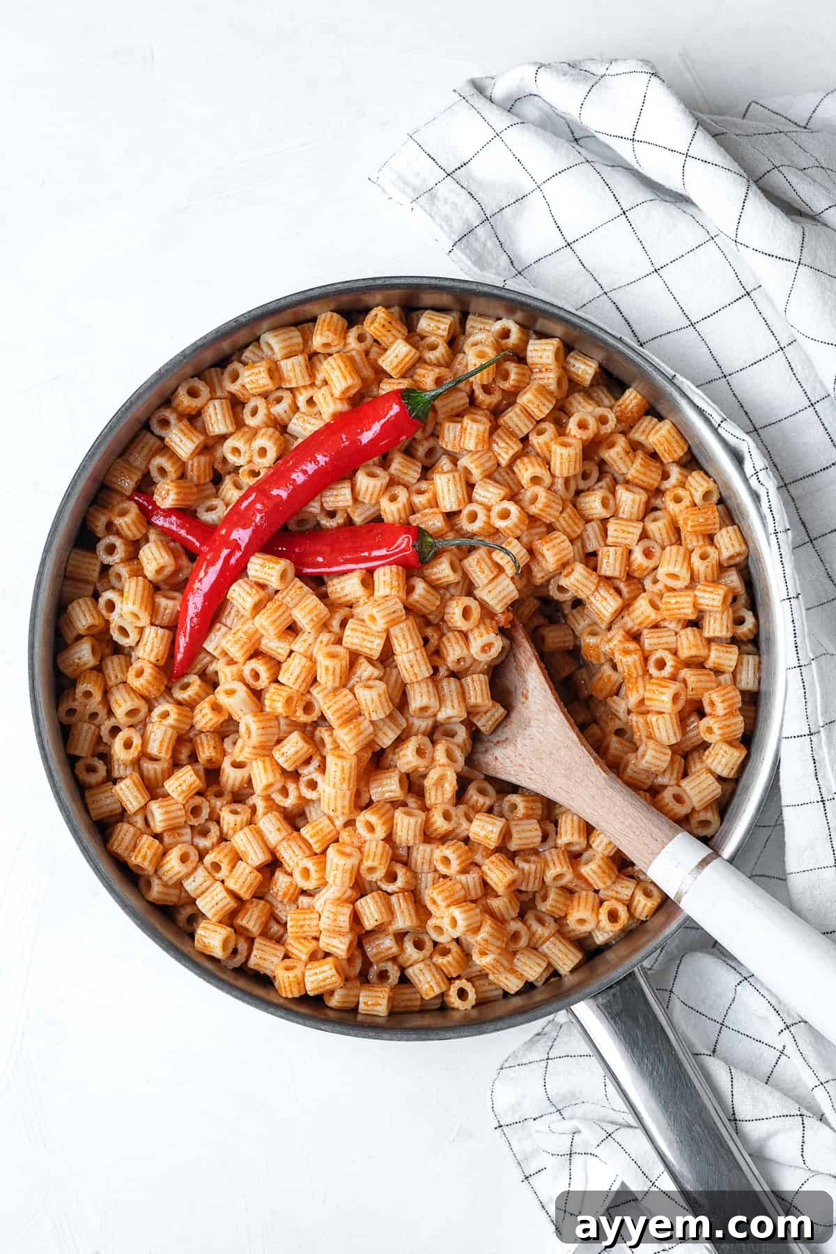 one pot mbakbaka topped with peppers with a spoon sticking out