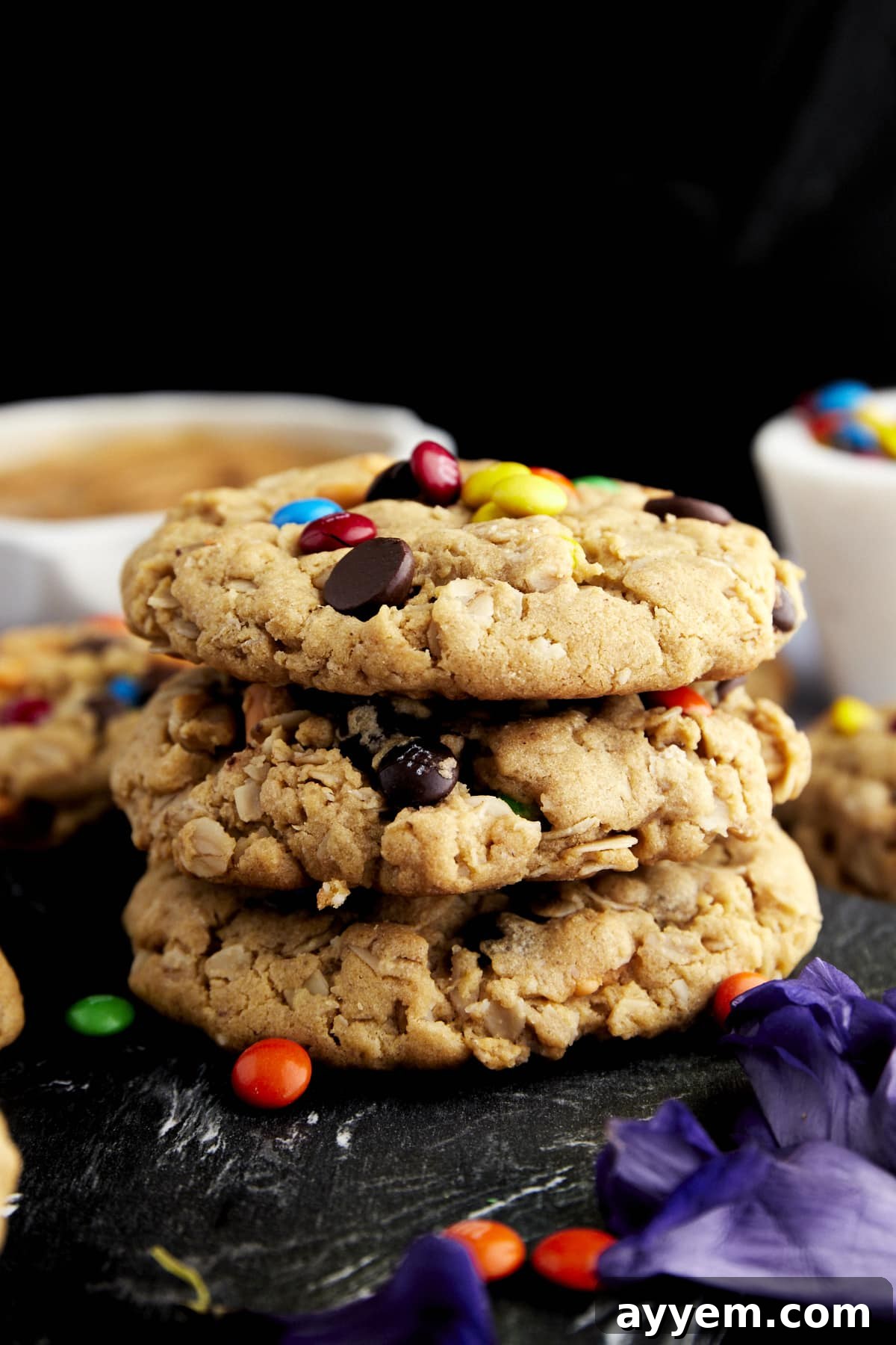 Fully Loaded Monster Cookies 3 A perfectly stacked trio of thick, delectable Monster Cookies, showcasing their rich texture and abundant mix-ins.