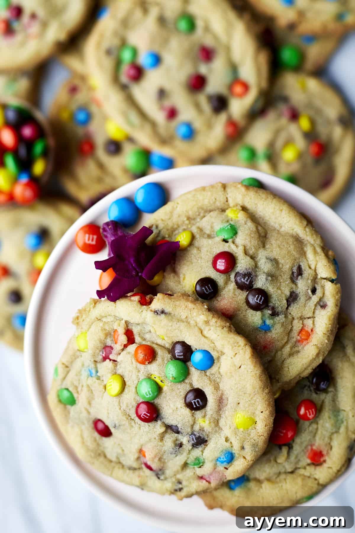 Close-up of a stack of soft-baked M&M cookies with perfectly melted chocolate and vibrant candy shells.