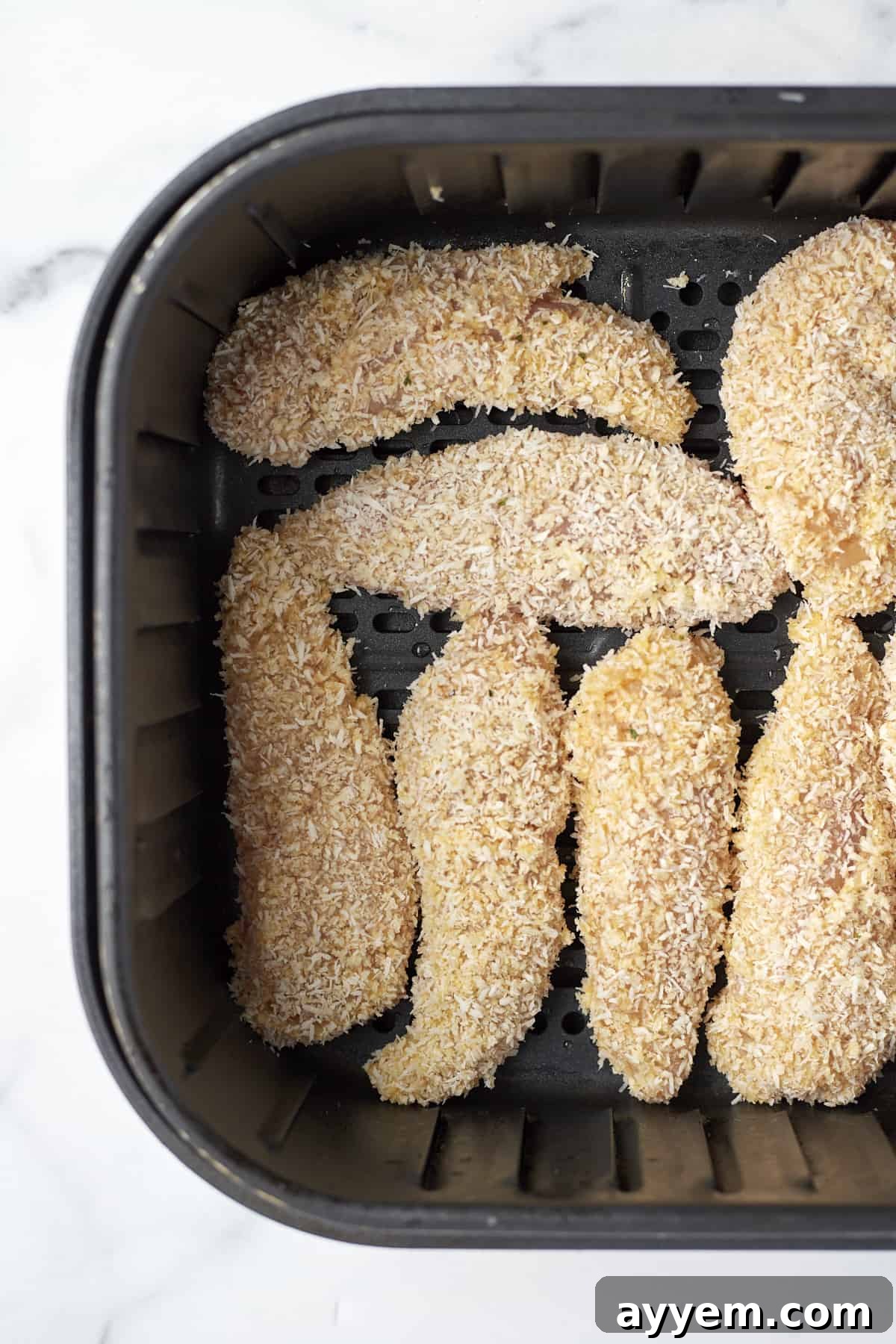 Island-Style Coconut Chicken Tenders 6 raw coconut chicken tenders in an air fryer