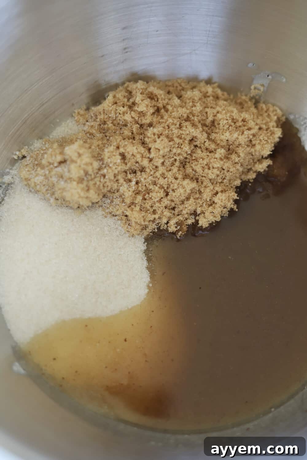 A bowl filled with brown sugar, granulated sugar, and vanilla extract, ready to be combined for the perfect toffee cookie dough