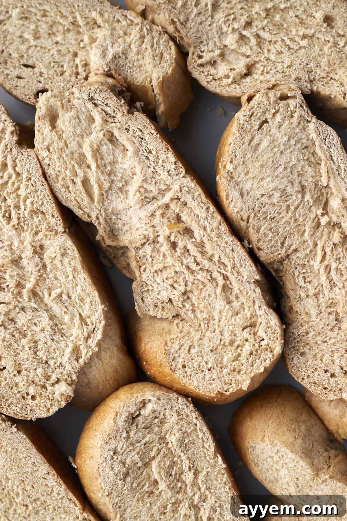 Sliced challah bread arranged neatly on a sheet pan, ready for the French toast custard.
