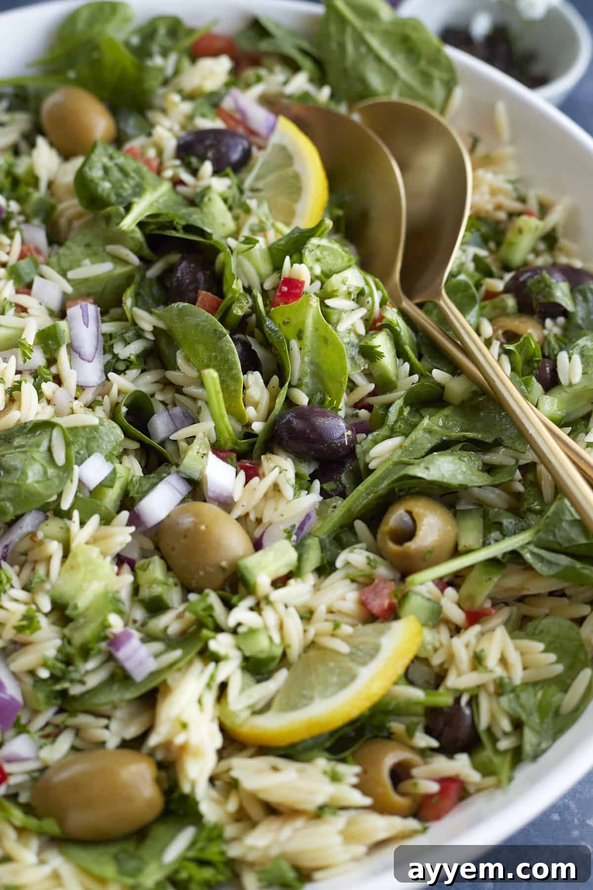 A close-up view of a vibrant Greek orzo pasta salad, showcasing its fresh ingredients and inviting texture.