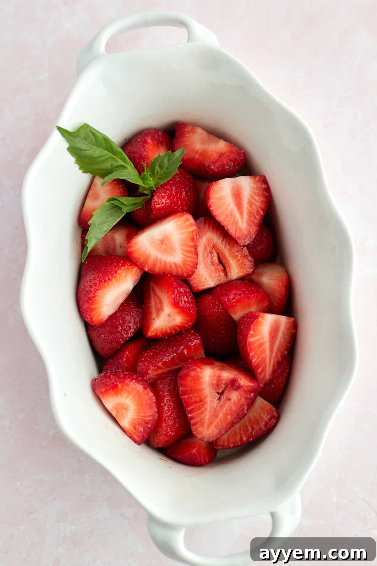 Strawberries in a baking dish with fresh basil