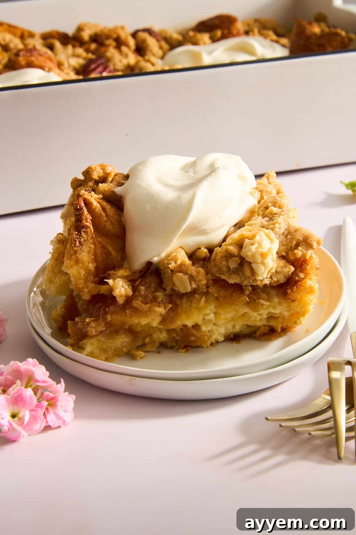 Decadent Pecan Croissant Pudding 8 Close-up of baked pecan pie croissant bread pudding with a scoop missing.