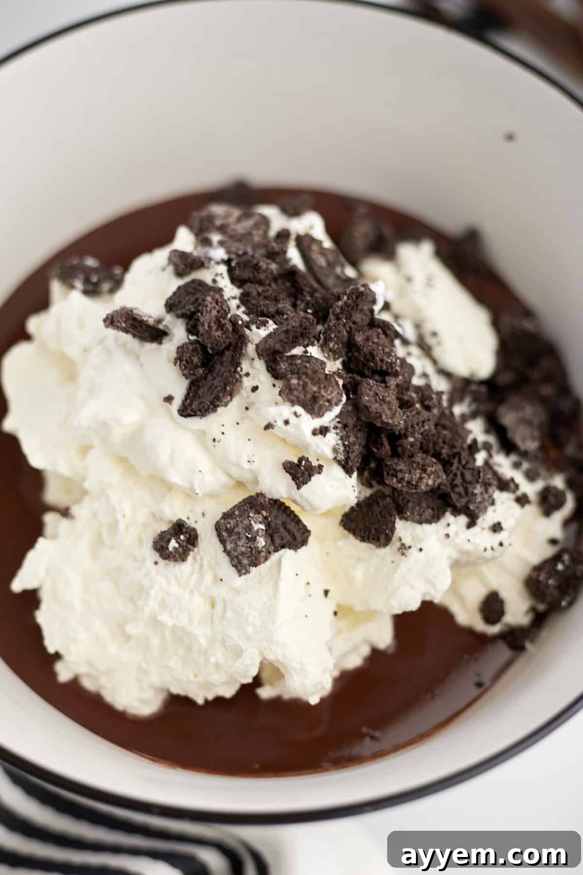 bowl of melted chocolate with whipped cream and oreos