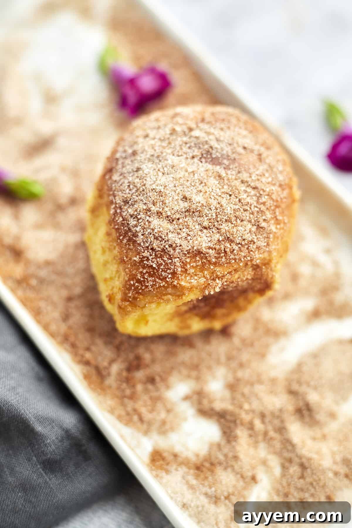 a close up image of a cinnamon bun air fryer french toast bun