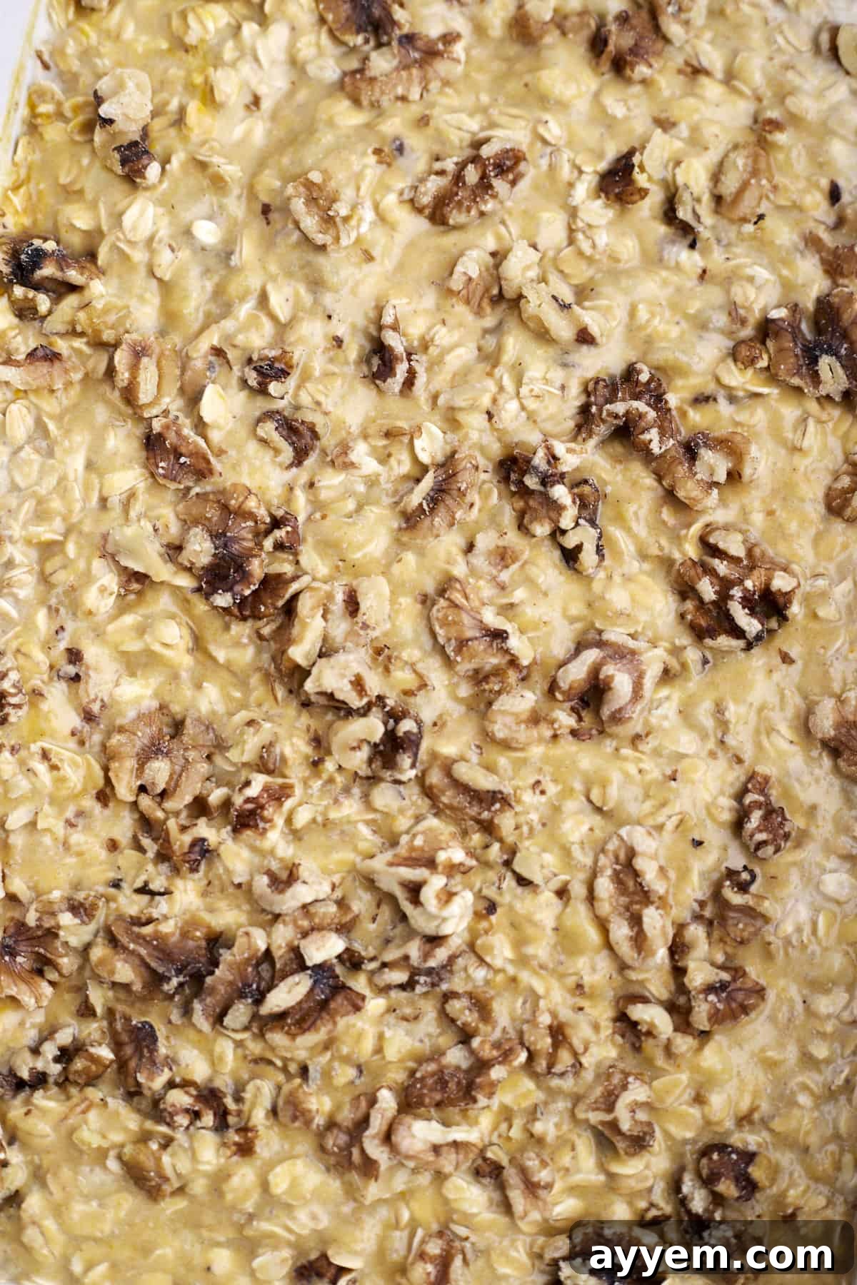 Close-up image of baked oatmeal with pumpkin, nuts, and a hint of spice.