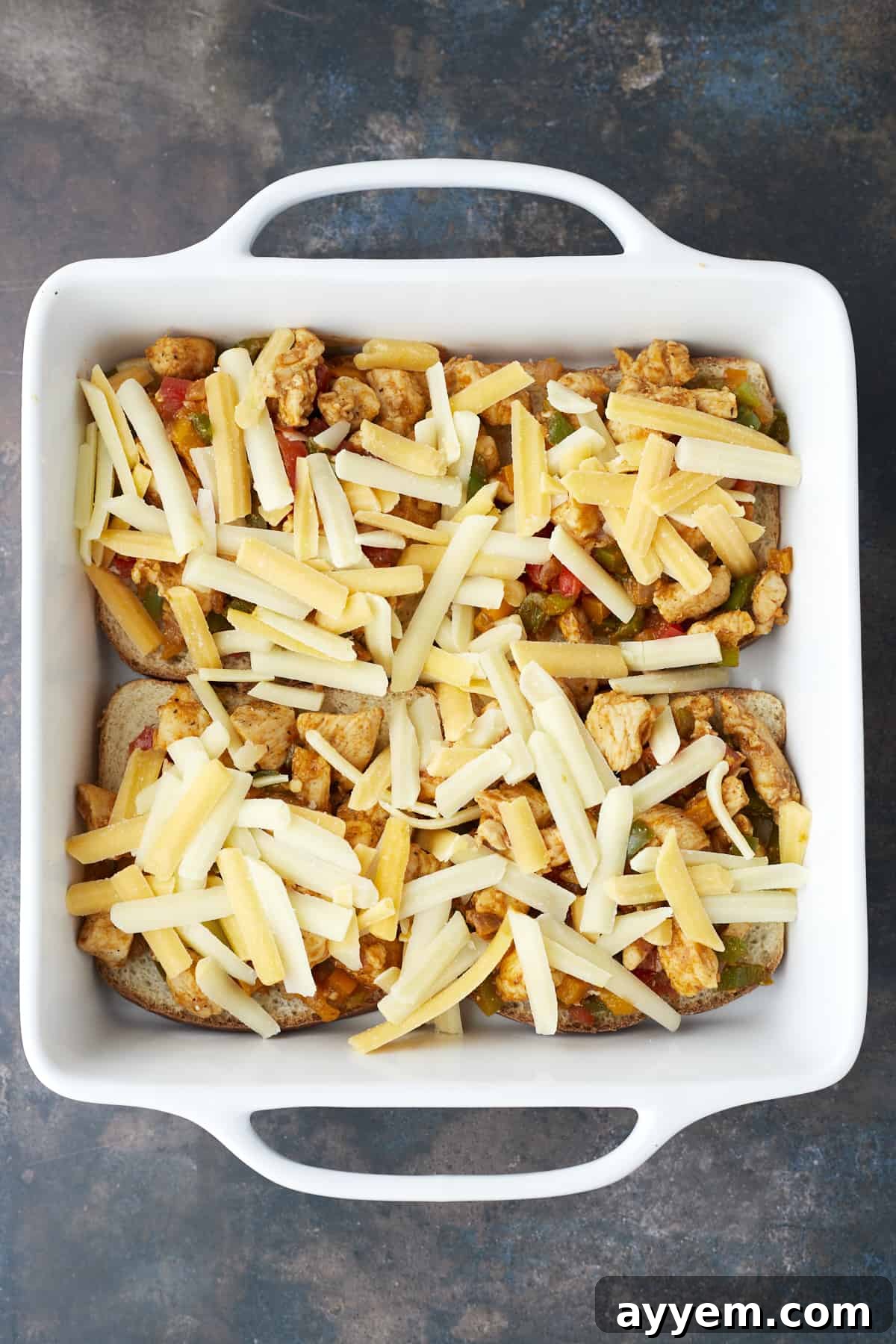four pieces of bread in a baking dish topped with fajita chicken and cheese