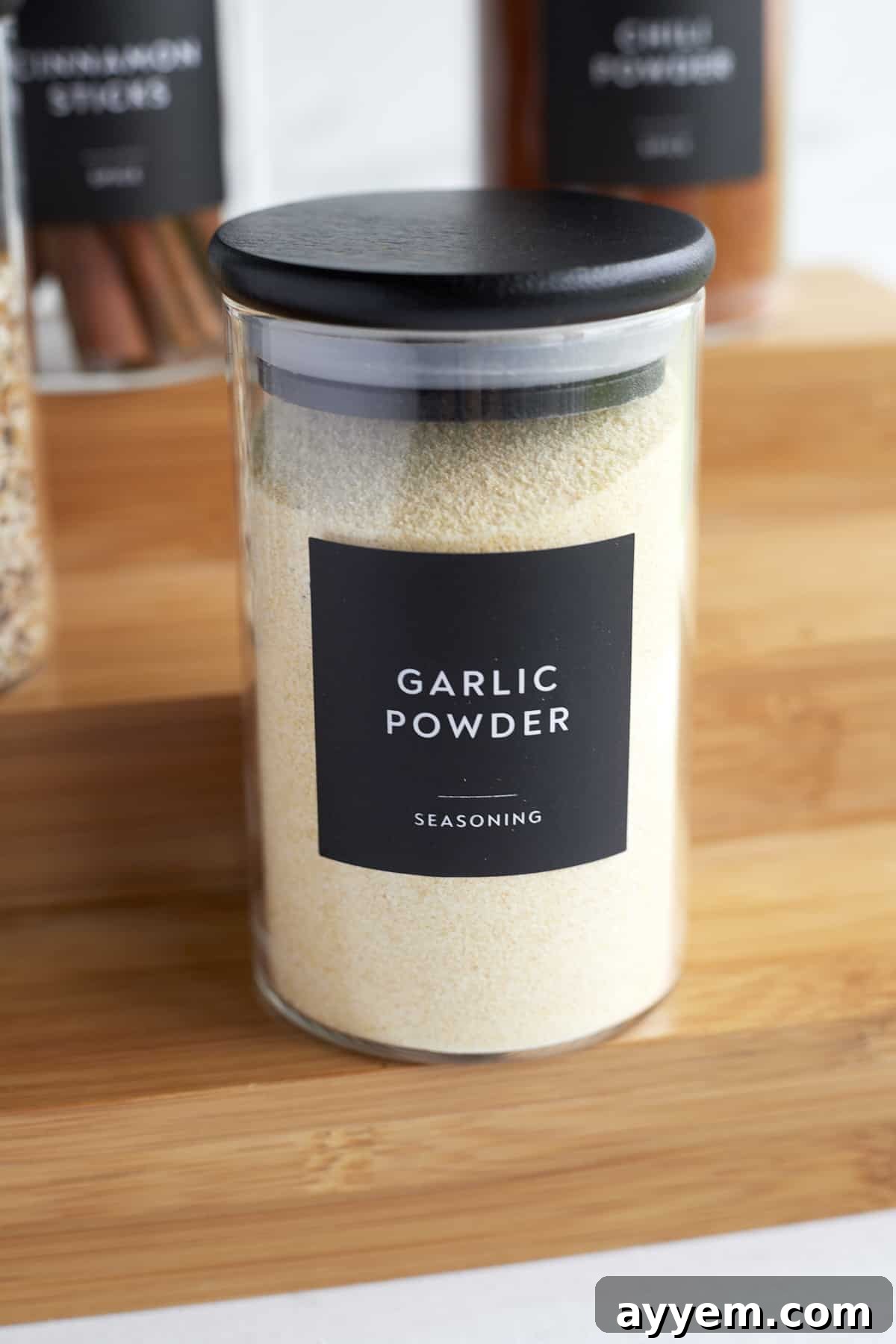A perfectly labeled clear spice jar containing garlic powder, highlighting the importance of clear labeling for an organized spice collection.