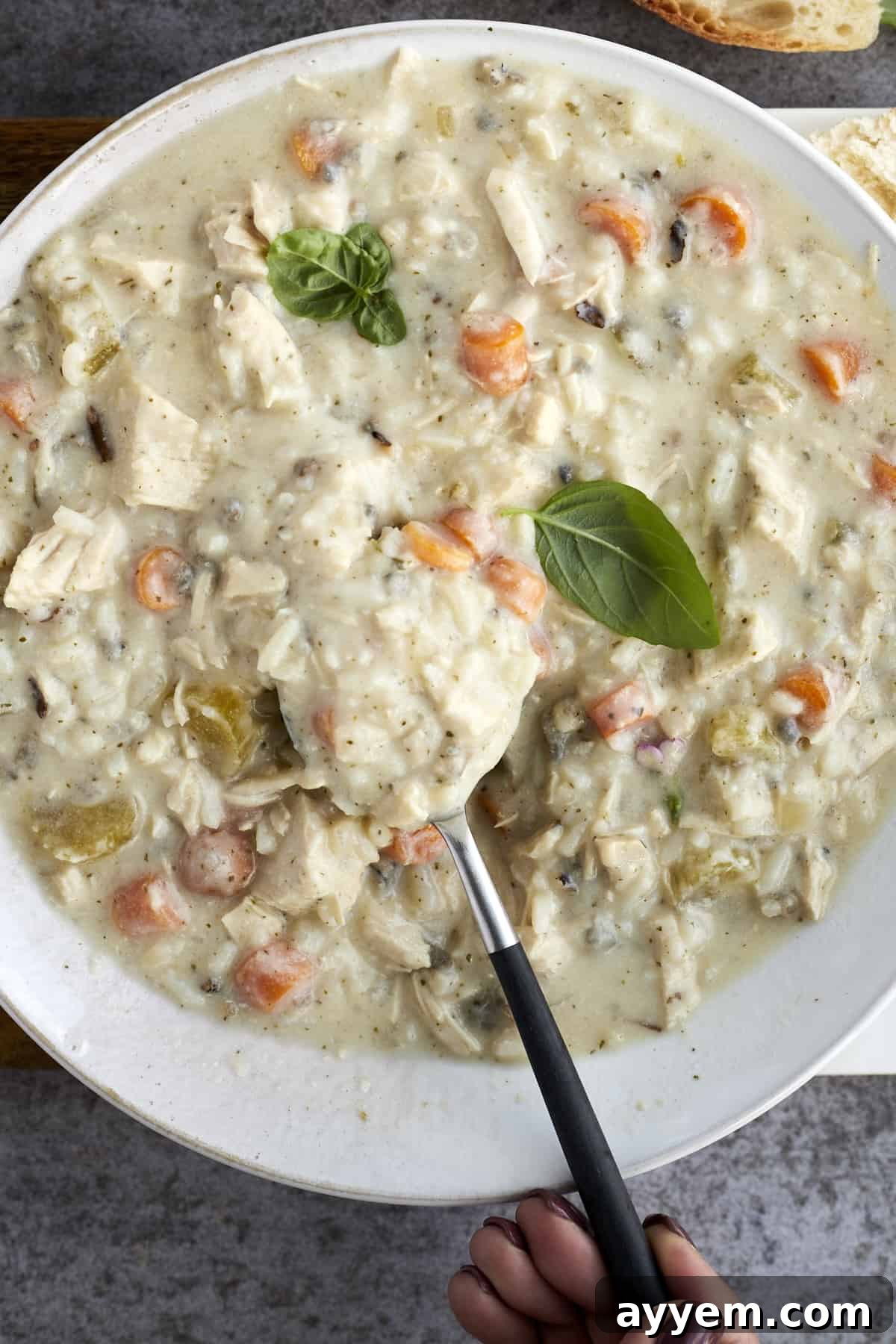 creamy chicken wild rice soup in a bowl with a spoon sticking out 
