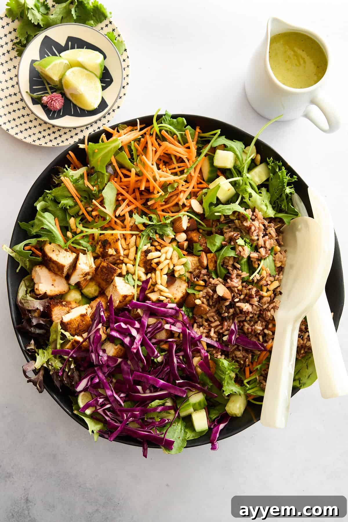 A selection of fresh, colorful ingredients for a SweetGreen copycat salad laid out on a table, including sliced chicken, crispy quinoa, and various vegetables.