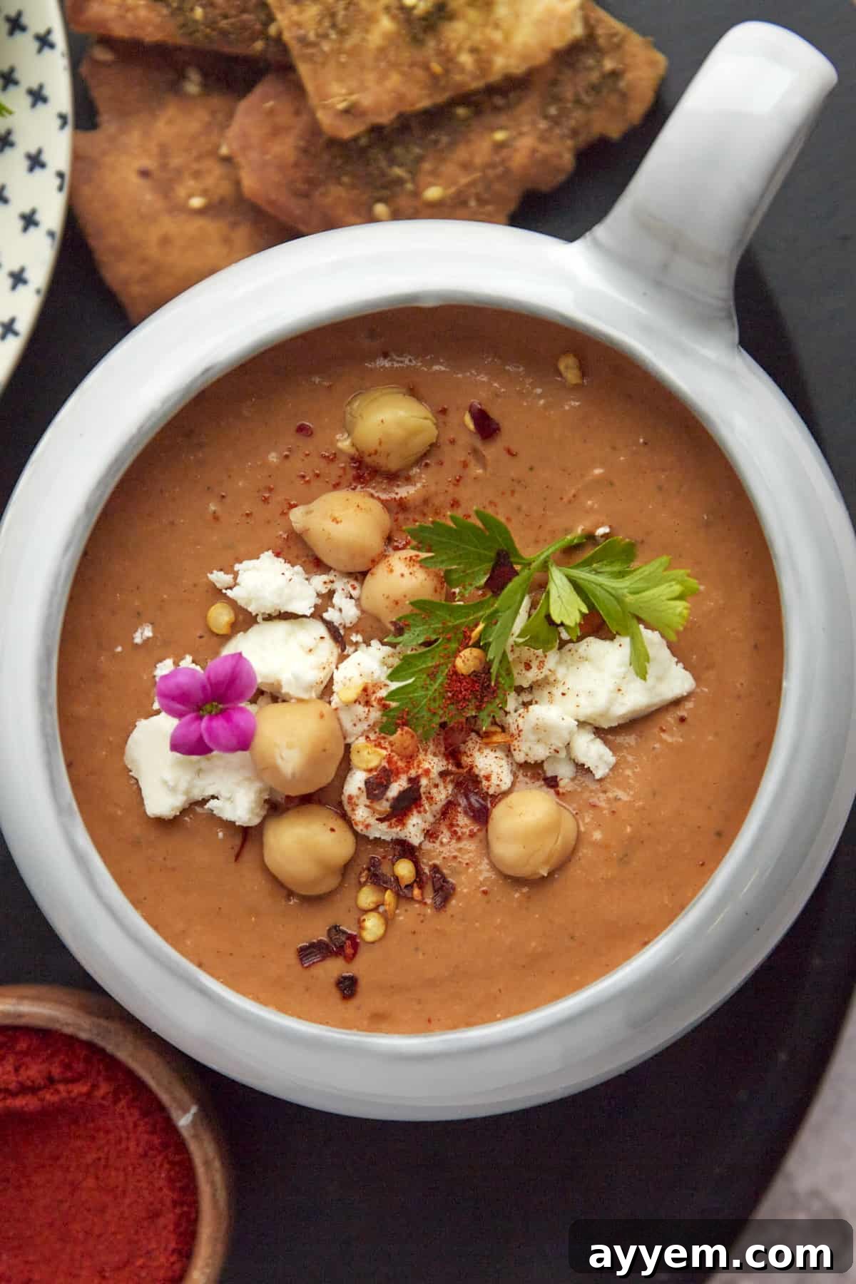 overhead image of a bowl of Moroccan Spicy Tomato Soup with air fryer pita chips on the side