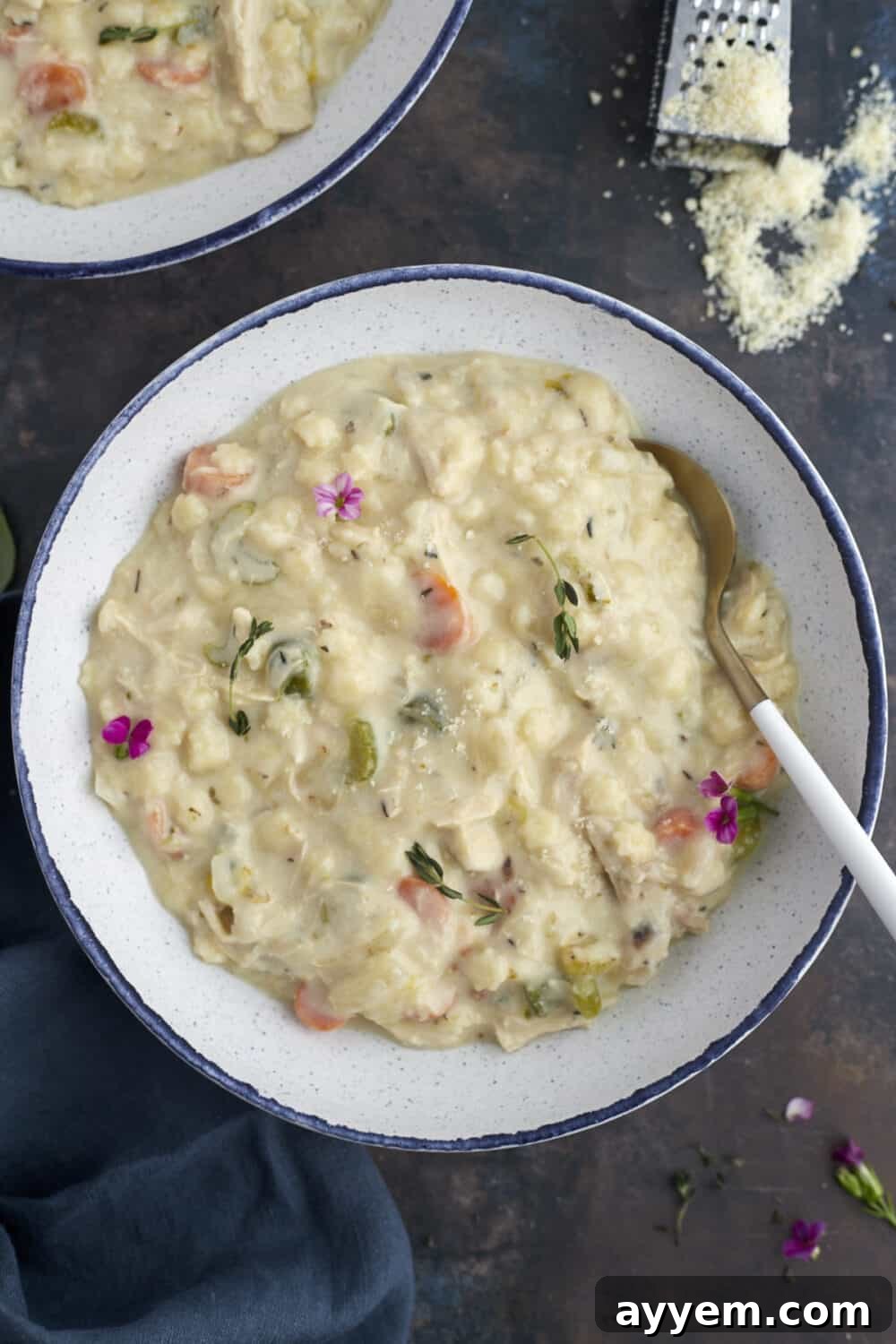 A close-up shot of a bowl of creamy chicken noodle soup, with a spoon resting in it, showcasing the vibrant vegetables and luscious broth.