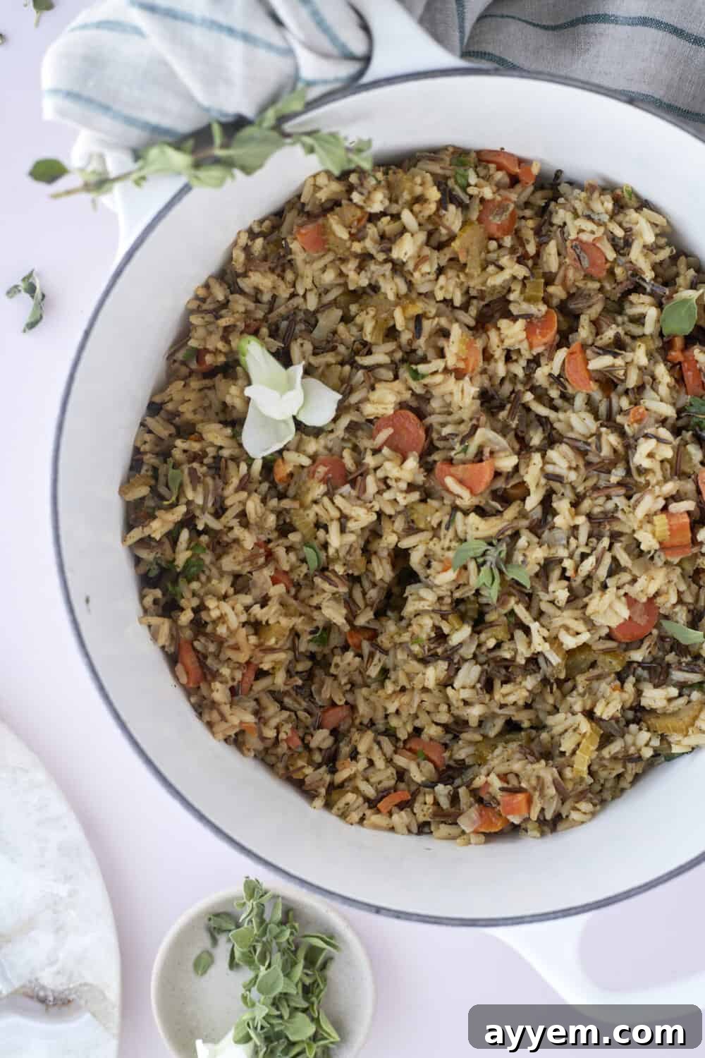 A beautifully presented bowl of seasoned rice pilaf, garnished with fresh herbs, showcasing its rich texture and vibrant vegetables.