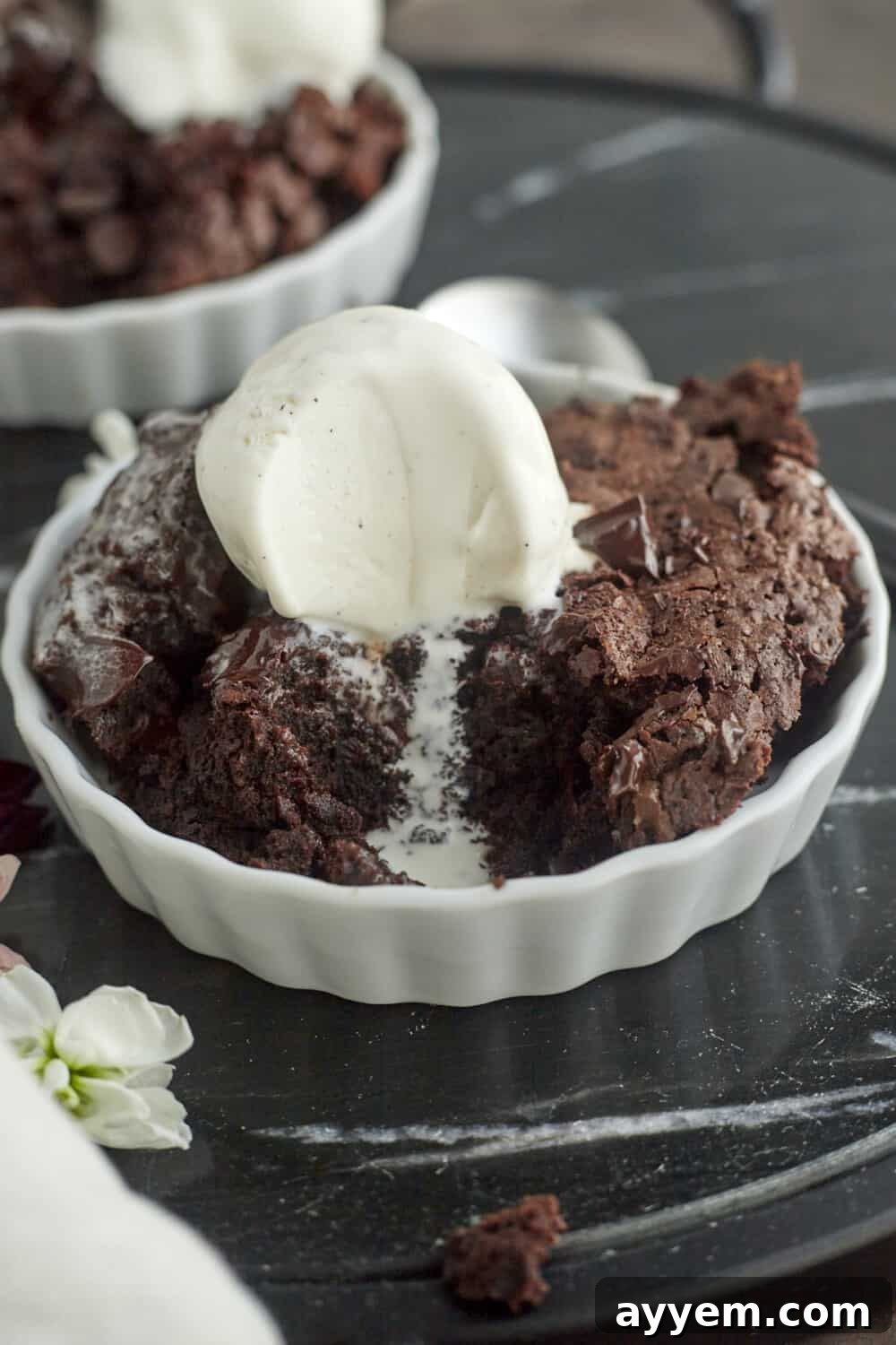 A single serving of Chocolate Hazelnut Skillet Brownie topped with a generous scoop of vanilla ice cream, ready to be enjoyed.
