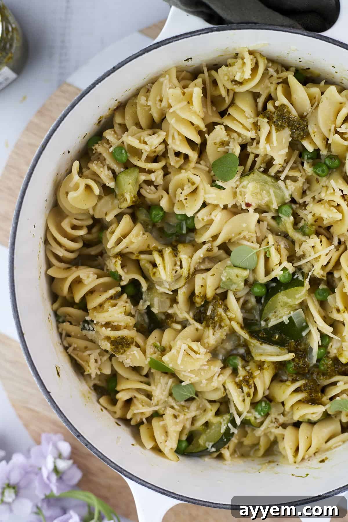 A vibrant and inviting image of creamy pesto pasta, ready to be served from a large pot. This one-pot recipe features pasta beautifully coated in green pesto, mixed with fresh vegetables.