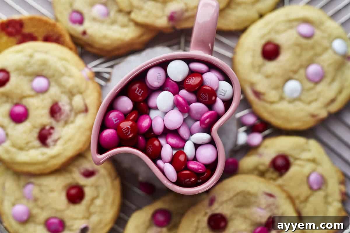 A bowl of Valentine's M&Ms surrounded by baked sugar cookies