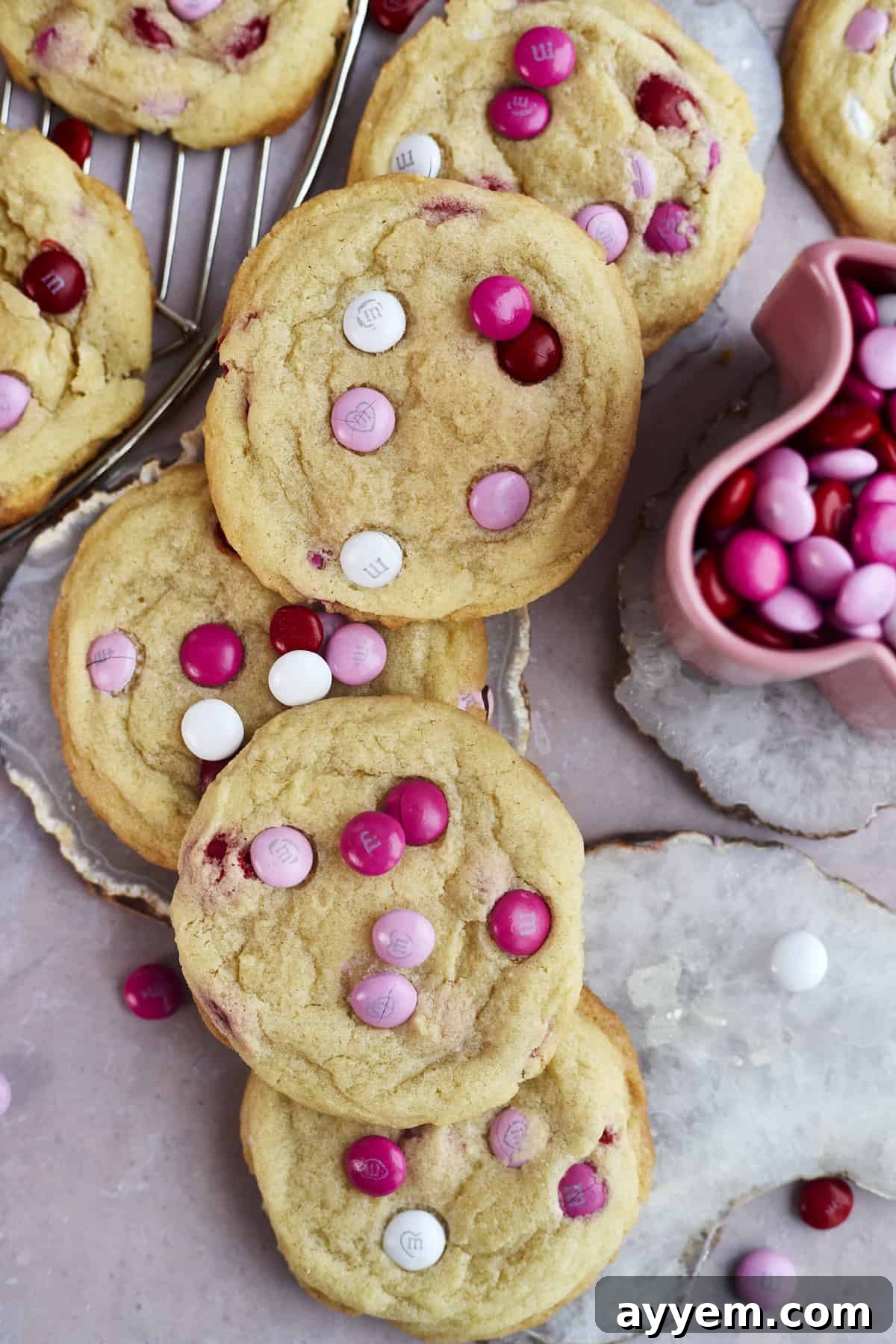 Valentine's Day M&M sugar cookies on a white plate next to a cup of M&Ms