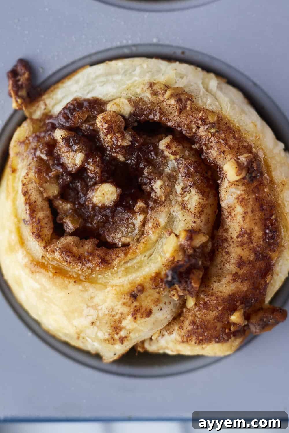 Baklava Puff Pastry Cinnamon Rolls with honey being drizzled over them.