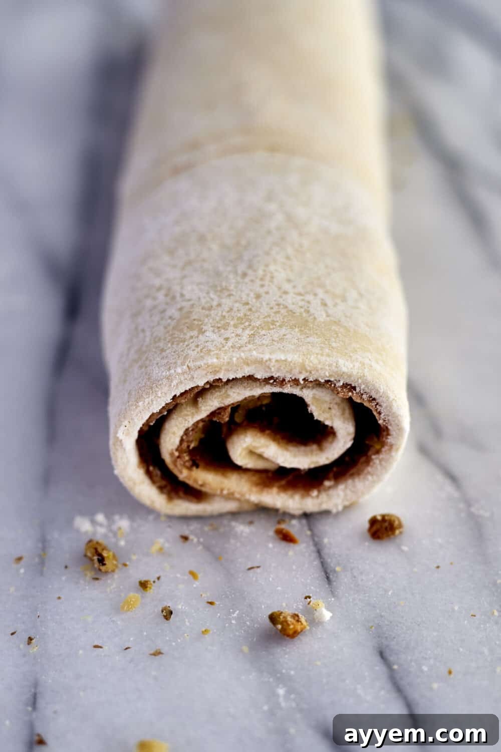 Preparation step 5: Rolled puff pastry being sliced into individual rolls.