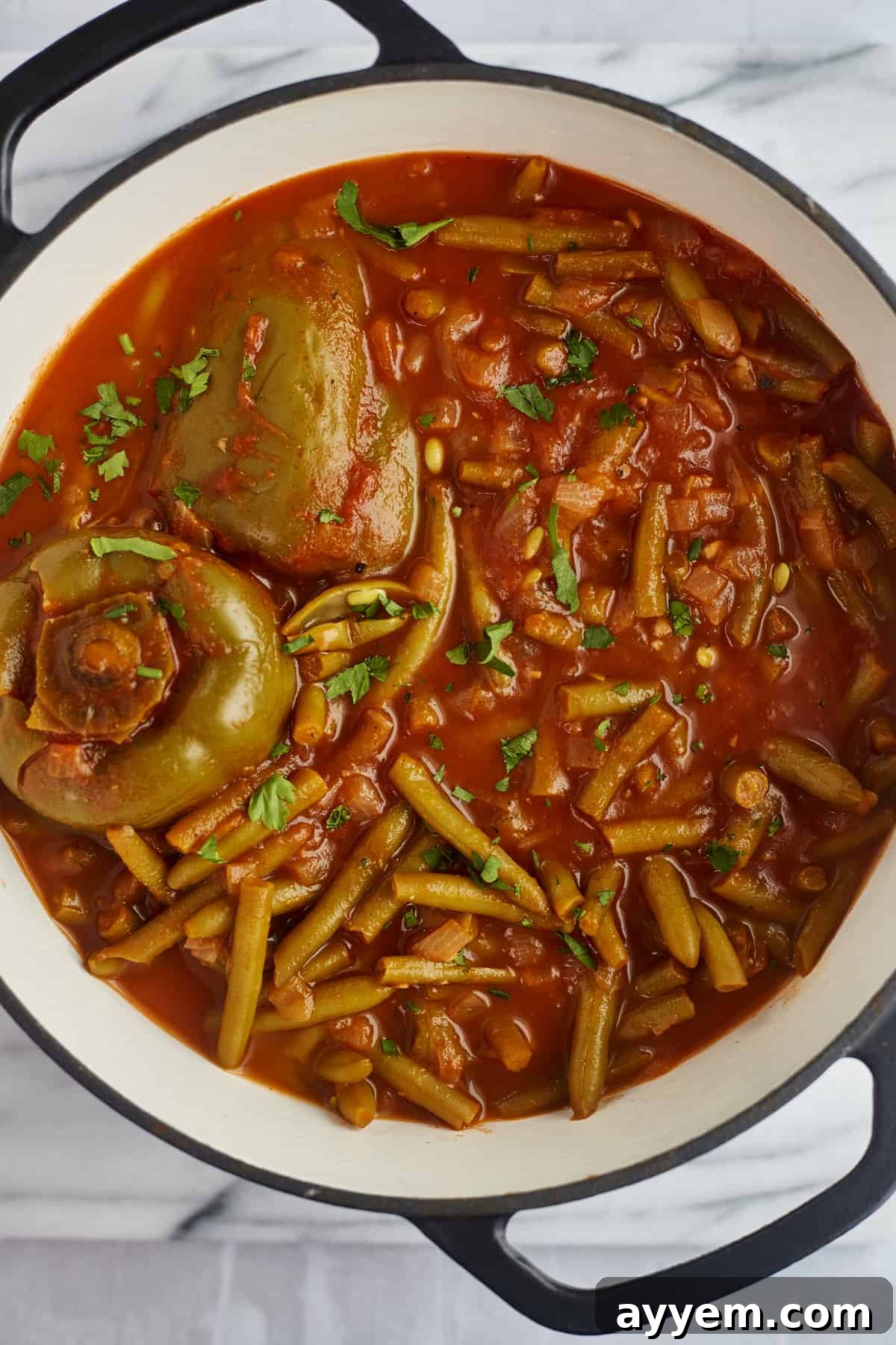 green bean stew with stuffed bell peppers in a large pot 