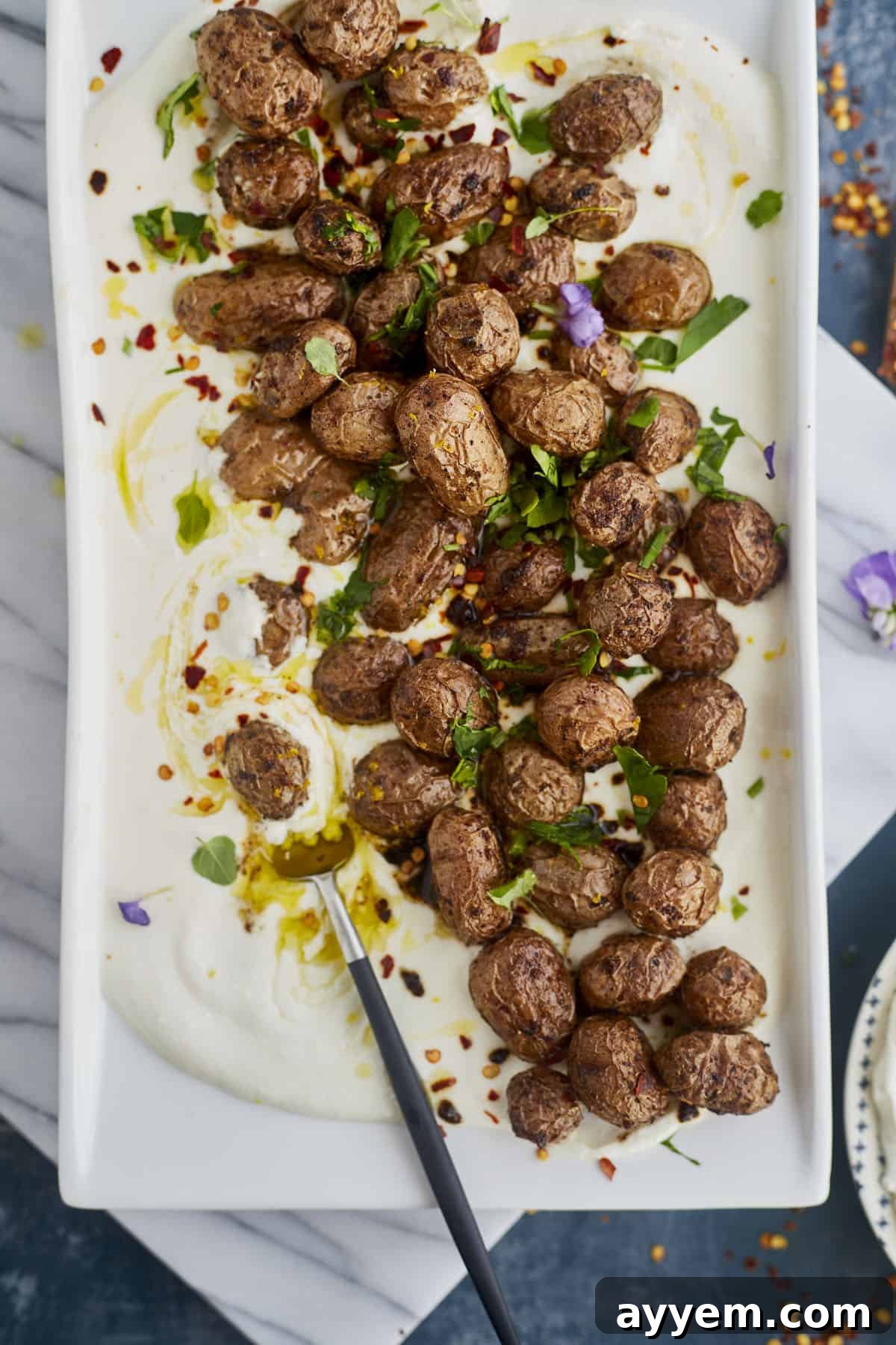A beautifully composed serving of Greek potatoes layered over velvety whipped feta, ready to be enjoyed as a savory appetizer or side.
