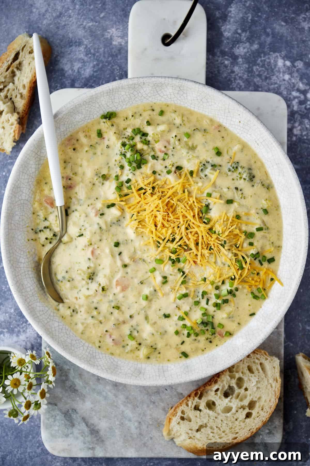 A bowl of broccoli and cheese soup with a spoon sticking out.