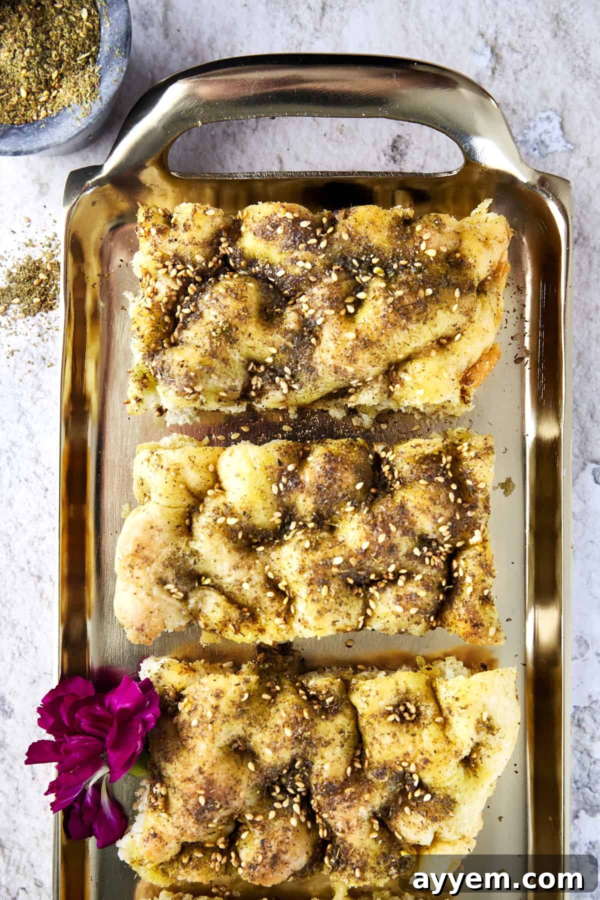 A freshly baked Quick Focaccia with Za'atar Seasoning, golden brown and garnished with herbs, ready to be enjoyed.
