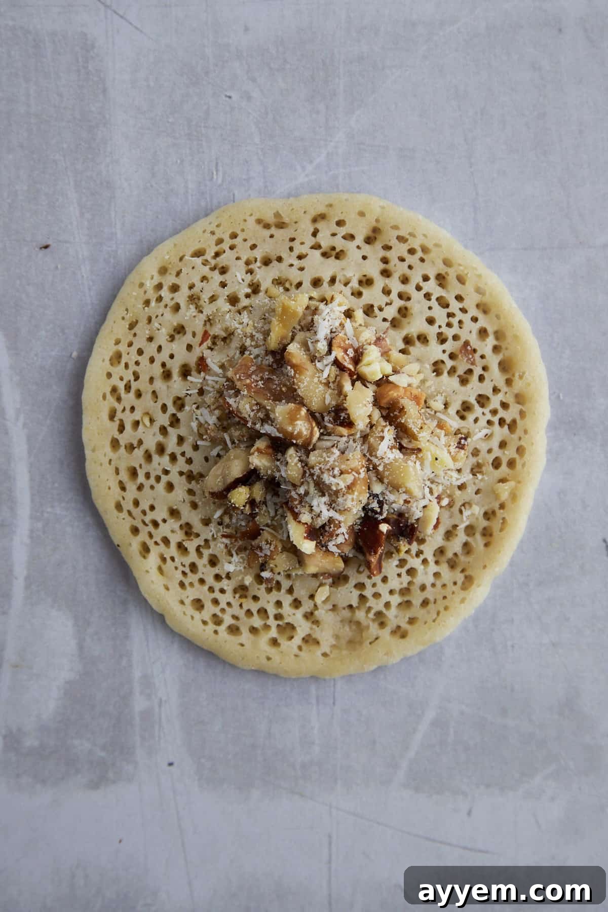 A Qatayef pancake being filled with the nut and sugar mixture.