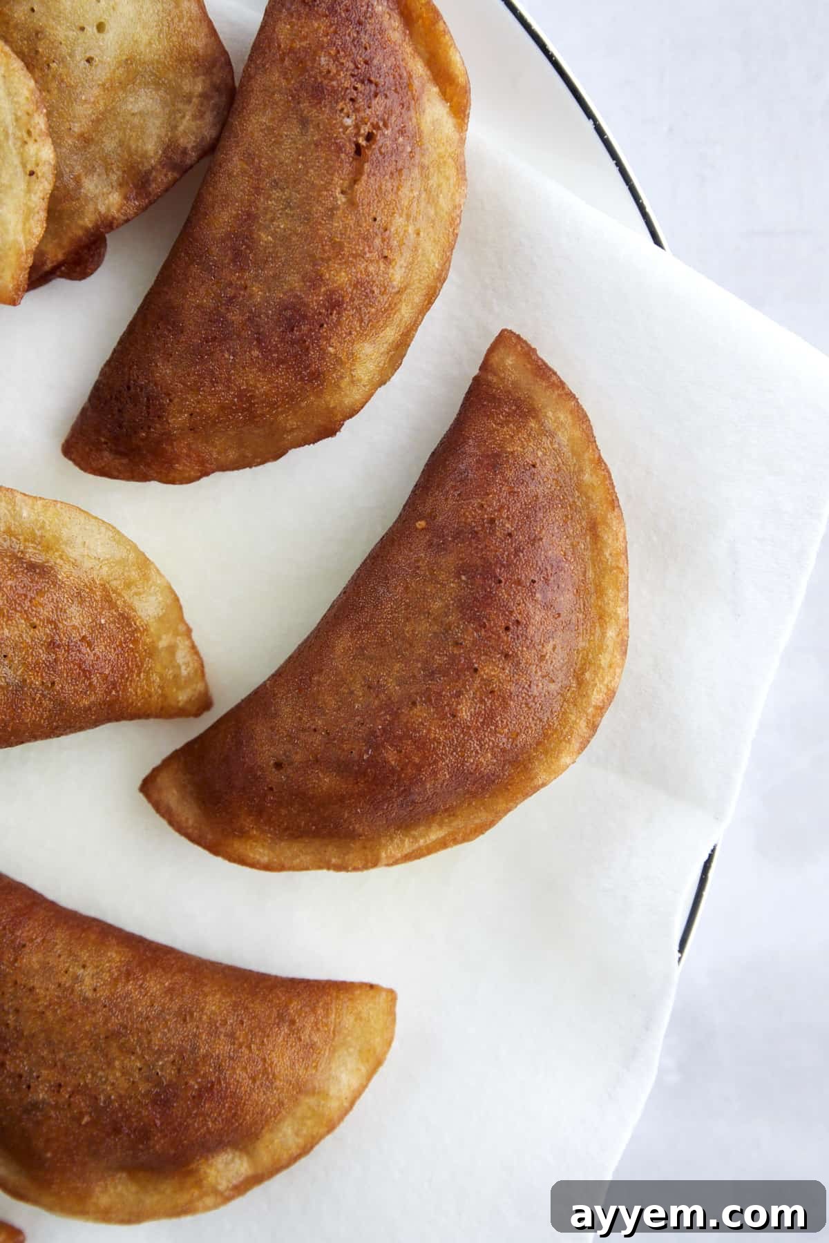 Freshly fried Qatayef on a plate, ready for syrup.